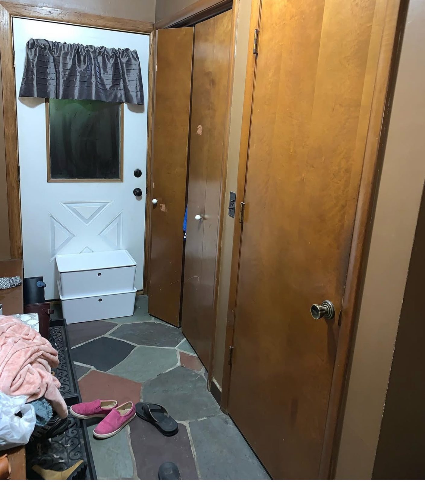 Before photo of breezeway in Grand Rapids with dark walls, older doors, and stone floor