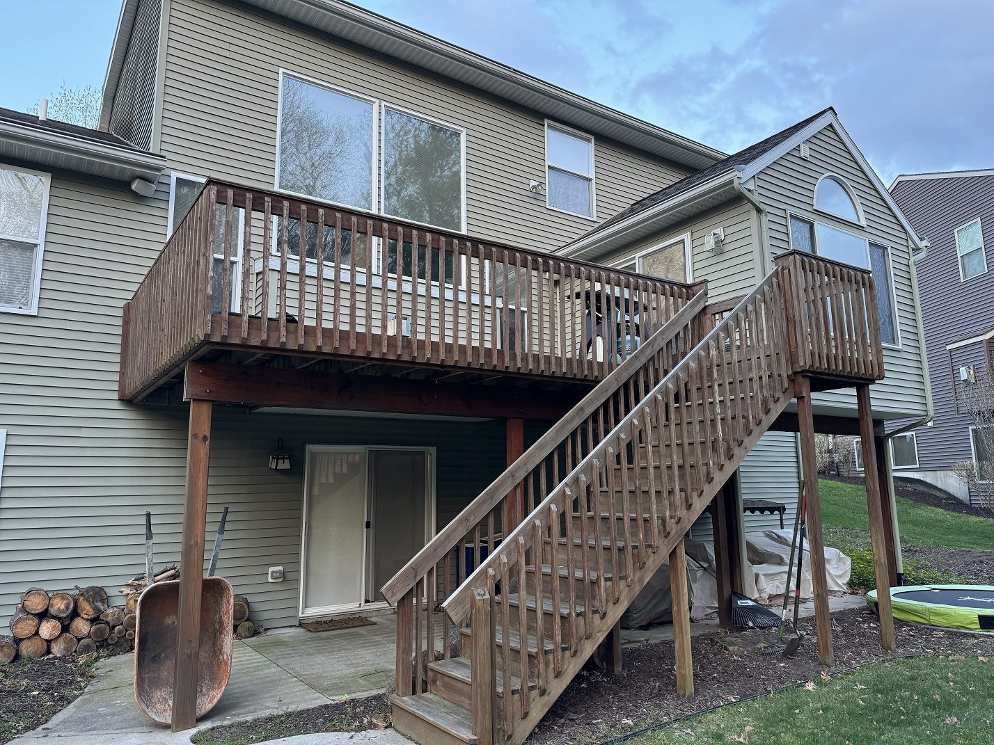 Before photo of backyard deck project in Grand Rapids with wood railing and open upper deck
