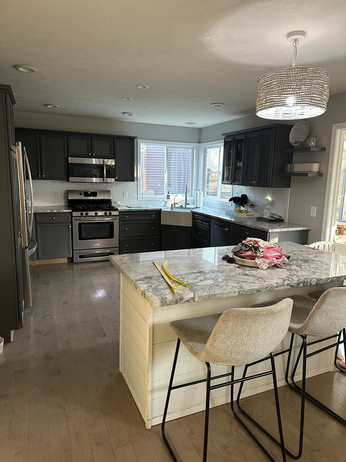 Finished kitchen remodel project in Grand Rapids with dark cabinets, white farmhouse sink, and updated lighting