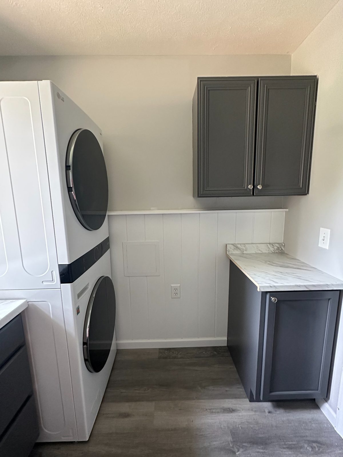 After photo of renovated laundry room in Grand Rapids with upper cabinet, lower storage, and new floor