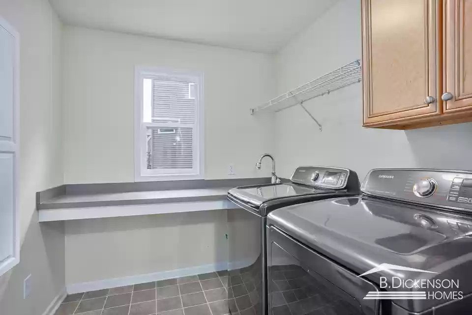 Before photo of laundry room in Grand Rapids with open counter, older flooring, and limited storage